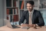 A confident lawyer working on a laptop in a law office.